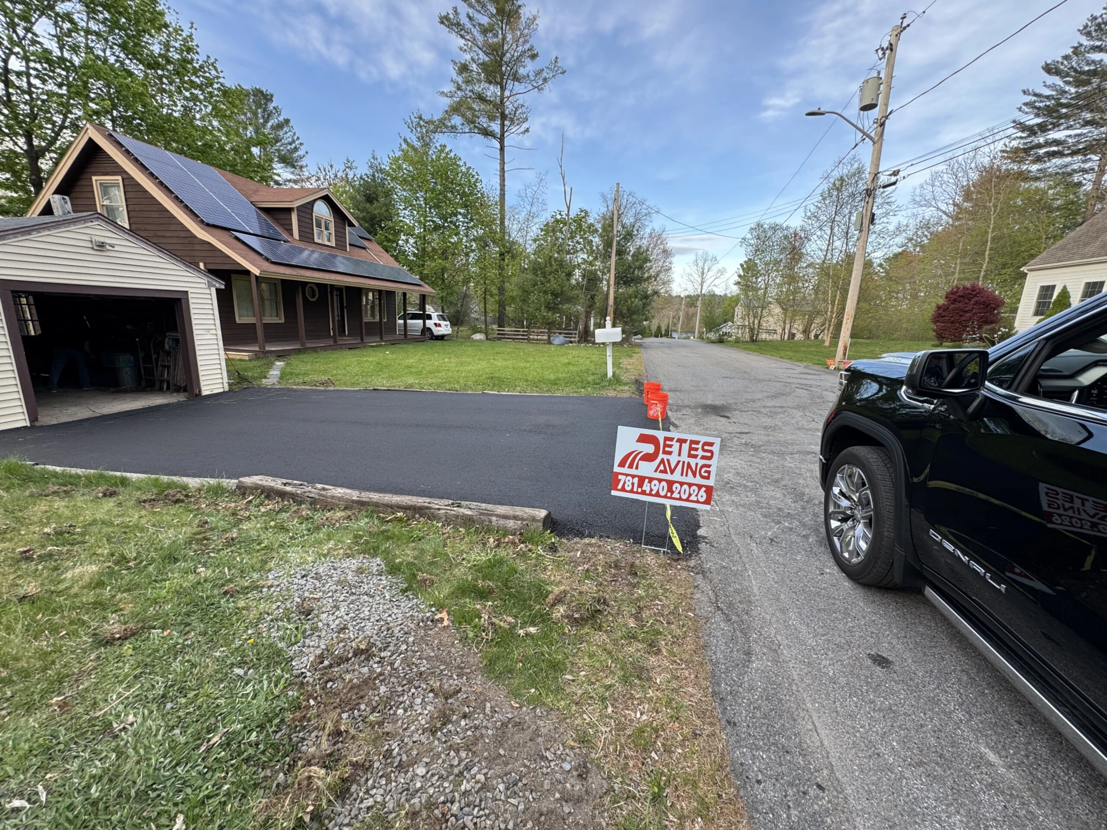 Freshly paved residential driveway with smooth asphalt finish in Marshfield, MA